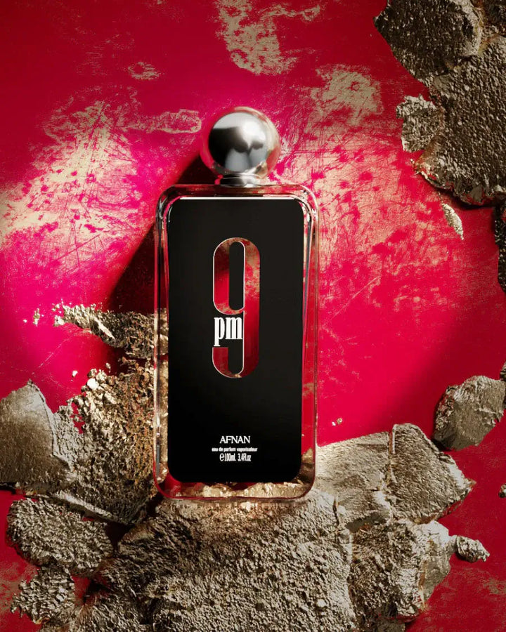 9 PM Rebel fragrance bottle on a textured background, showcasing its sleek design and luxurious appeal.